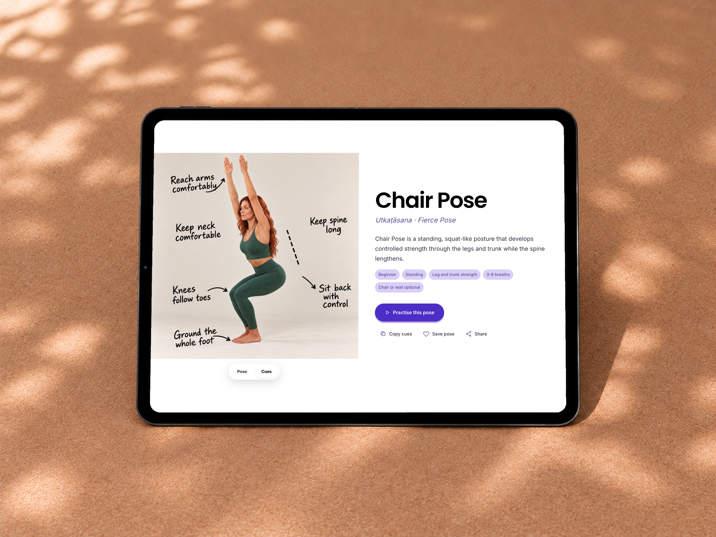 Yoga Space Chair Pose with alignment cues shown on an iPad on a sunlit cork surface